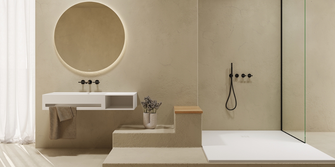 Baño moderno minimalista con lavabo flotante blanco, espejo redondo retroiluminado y ducha a nivel de suelo con grifería negra.