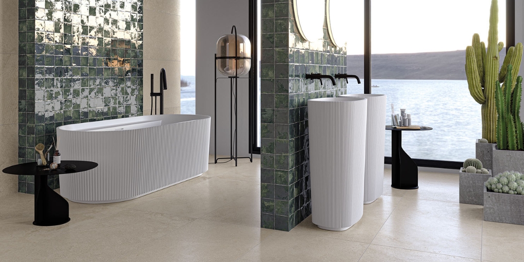 Baño de lujo con azulejos verdes brillantes, bañera exenta y lavabos de pie