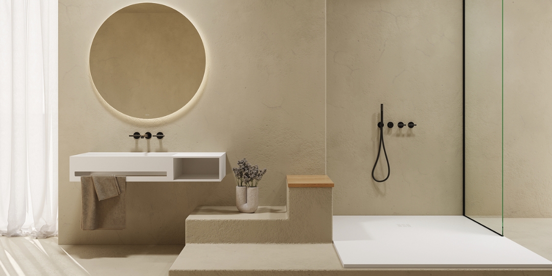 Baño moderno con revestimiento beige, espejo redondo retroiluminado, mueble suspendido blanco y ducha con grifería negra